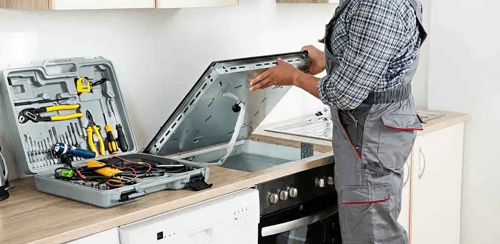 Handyman repairing a cooktop and checking wiring connections in Cleveland, OH