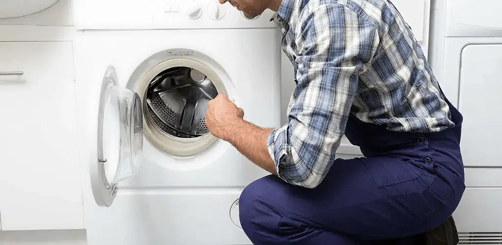 Handyman inspecting a dryer drum and internal parts for repair in Cleveland, OH