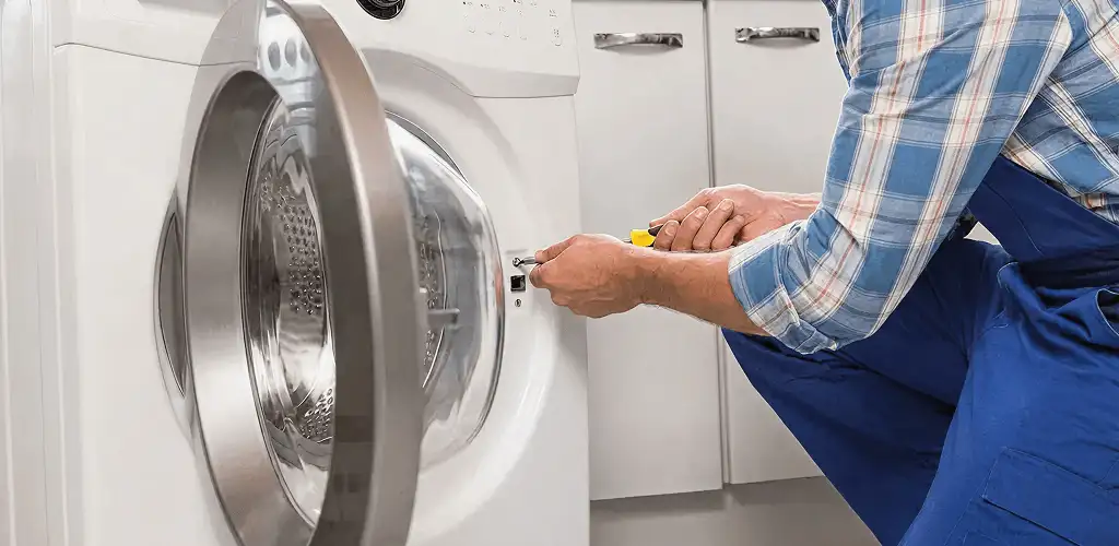 Handyman repairing a clothes dryer and checking electrical connections in Cleveland, OH