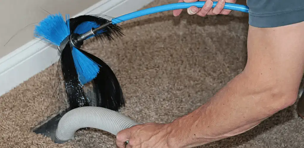Dryer vent cleaning technician brushing lint from a vent line in Cleveland, OH