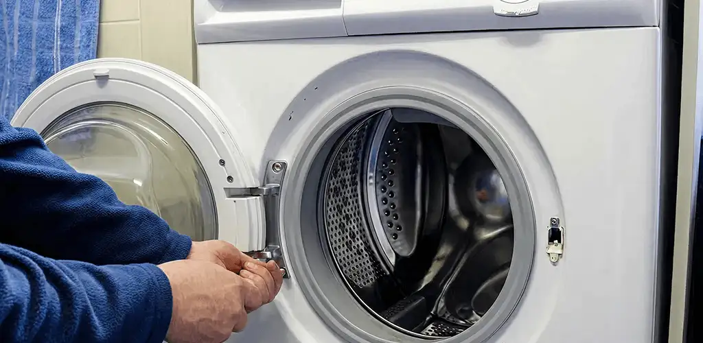 Washing machine repair handyman checking a front-load washer door and latch in Cleveland, OH