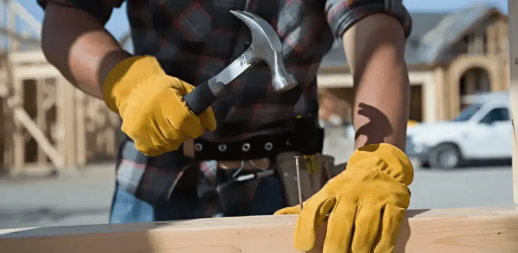 Handyman fixing wood trim with a hammer for home repairs in Cleveland, OH