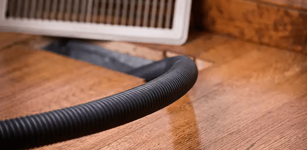 Air duct cleaning hose inserted into a floor vent for ductwork cleaning in Cleveland, OH