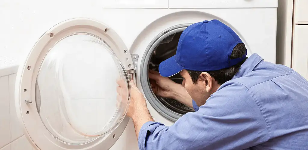 Washing machine repair handyman inspecting a front-load washer drum in Cleveland, OH