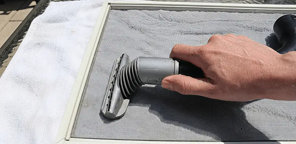 Window screen repair cleaning and fixing a damaged screen mesh in Cleveland, OH